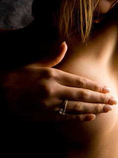 A woman checking her breast for lumps