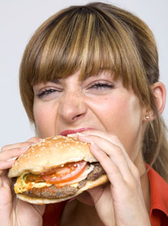 Marie Claire health news: Woman eating a burger