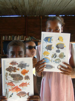 3 children holding fish charts in Madagascar
