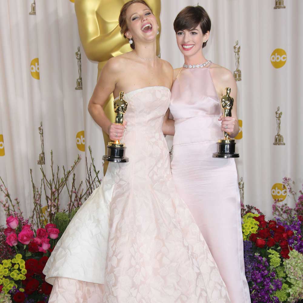 Jennifer Lawrence and Anne Hathaway share a joke at the Oscars 2013